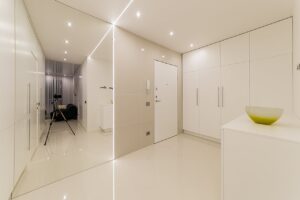 Elegant minimalist interior featuring white decor, modern furniture, and contemporary lighting setup.