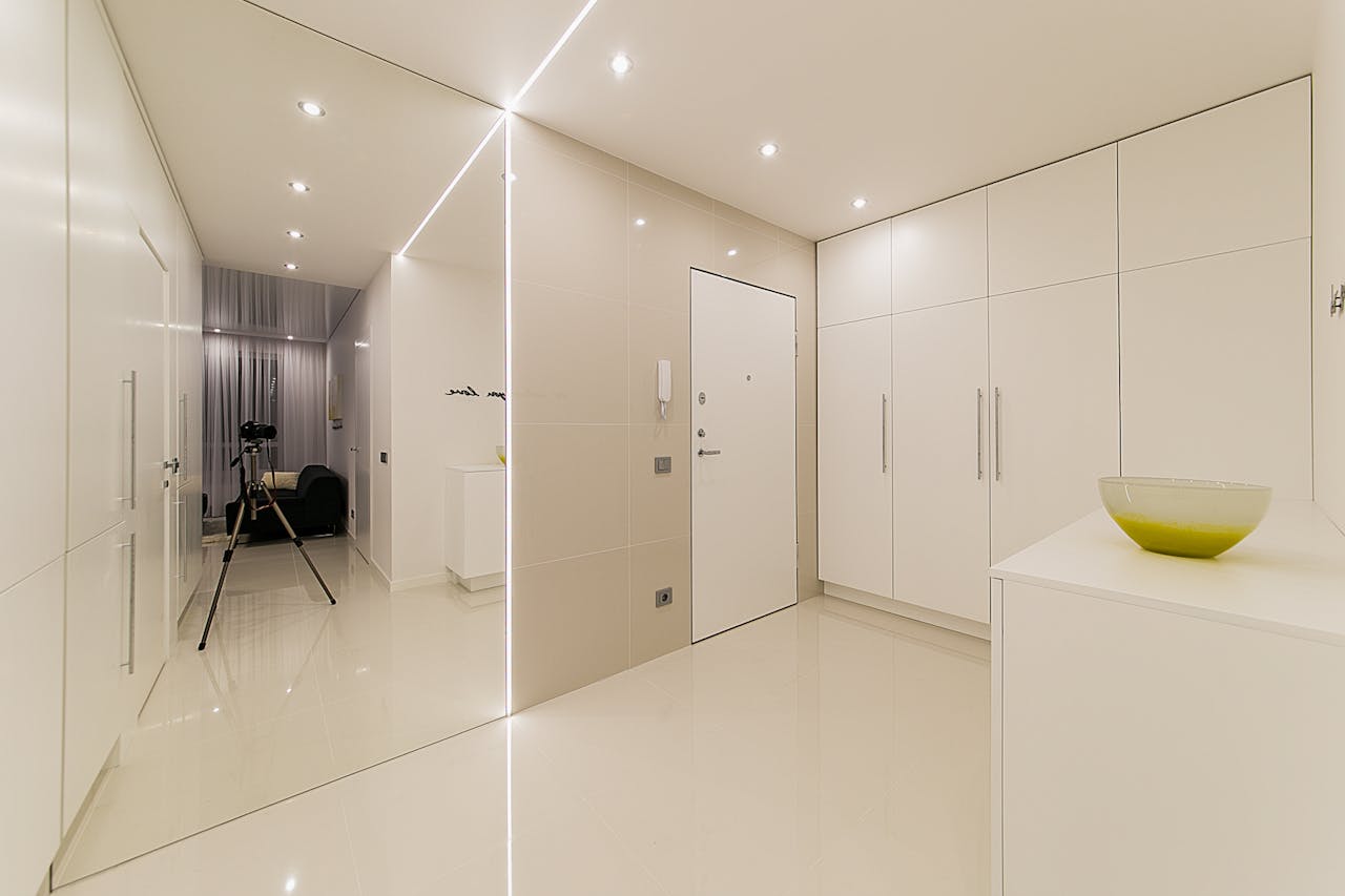 Elegant minimalist interior featuring white decor, modern furniture, and contemporary lighting setup.